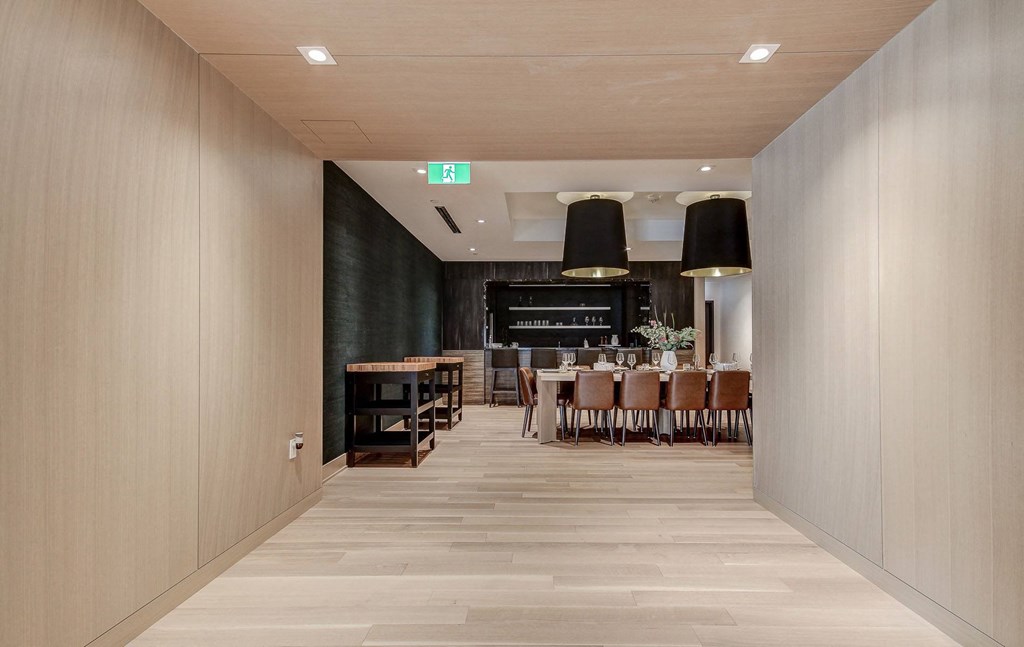 a dining room with wooden floors and a table and chairs in the distance