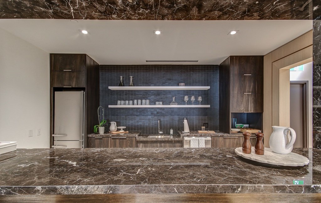 a kitchen with a marble counter top and a blue wall