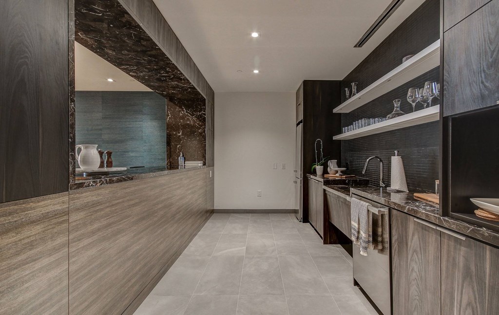 a large kitchen with wooden cabinets and marble counter tops