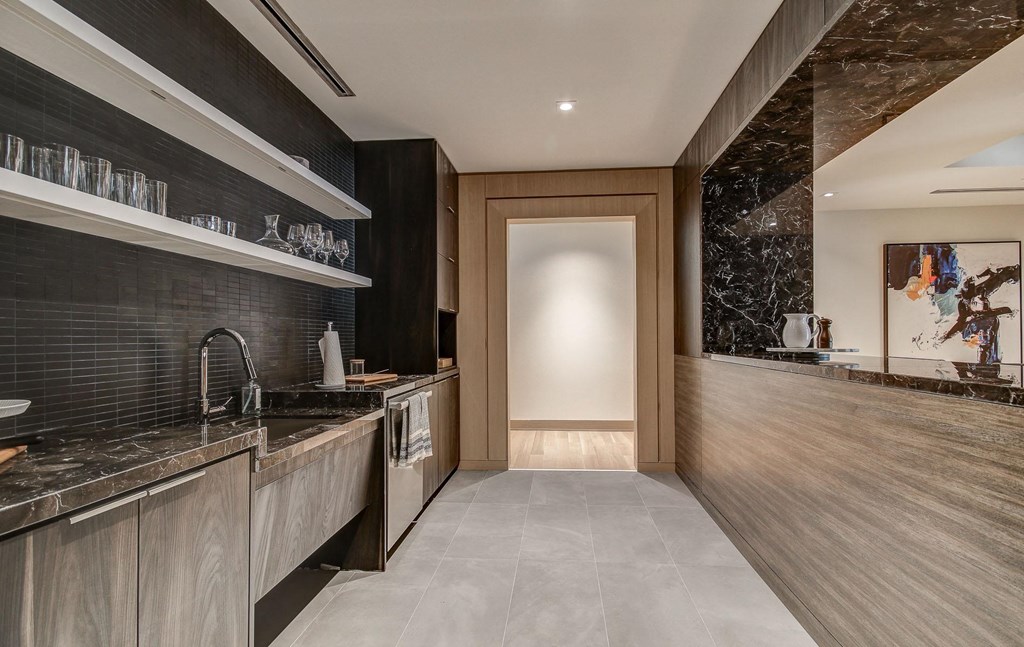 a kitchen with marble counter tops and a door to a hallway