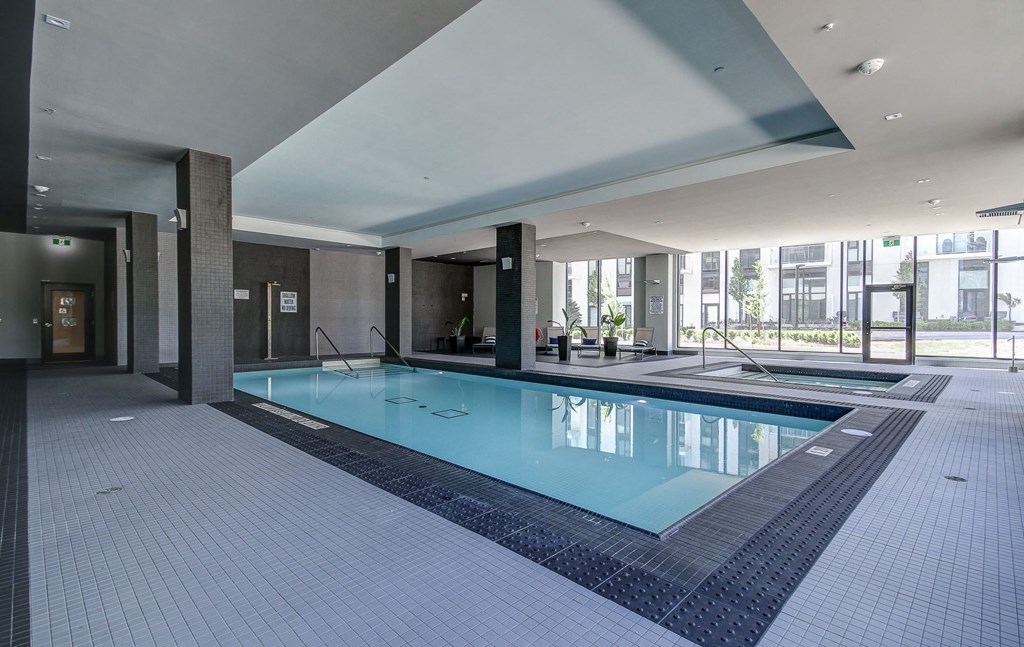a swimming pool in a lobby of a building with a glass door
