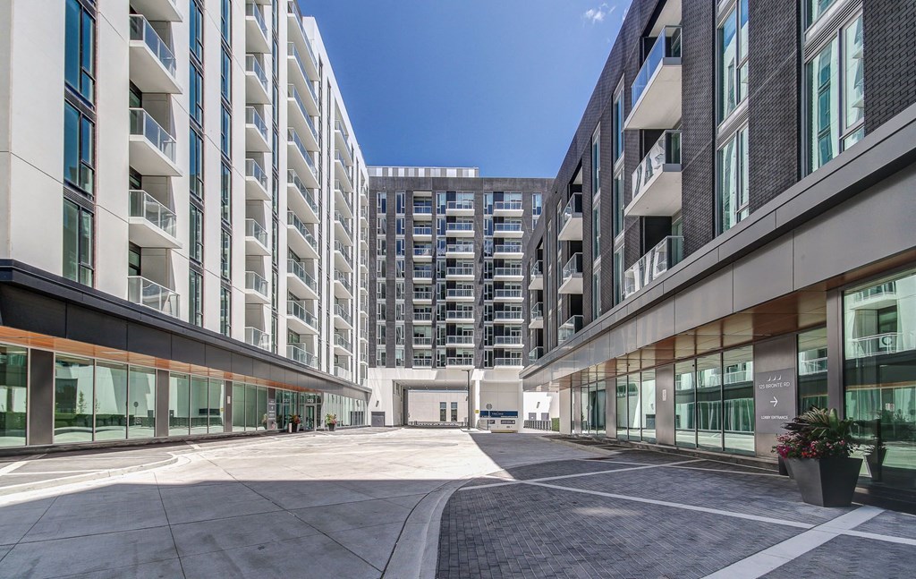 a courtyard between two buildings with a large building in the background