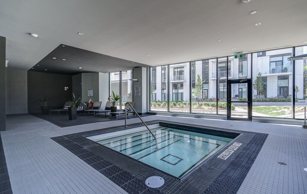 a swimming pool in the middle of a building with floor to ceiling windows