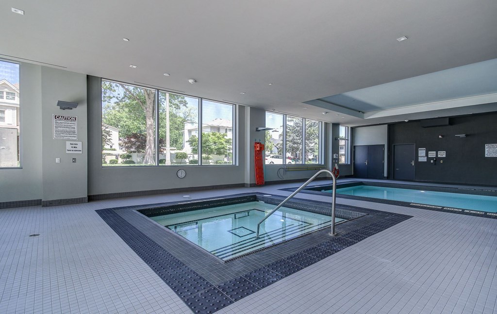 a swimming pool in the center of a large room with windows