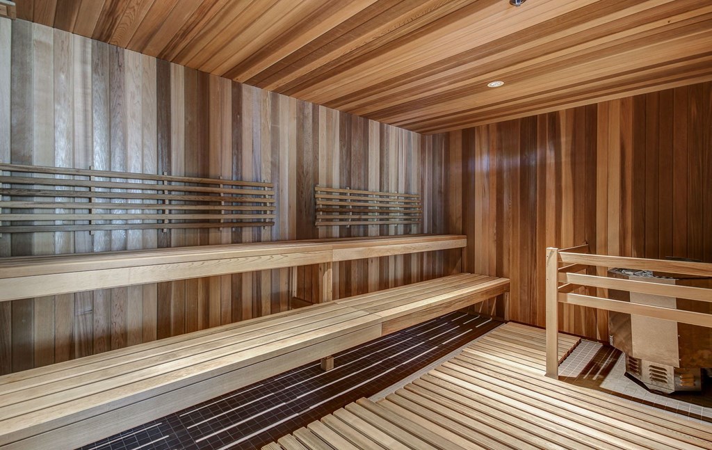 a sauna with wooden benches and a chair