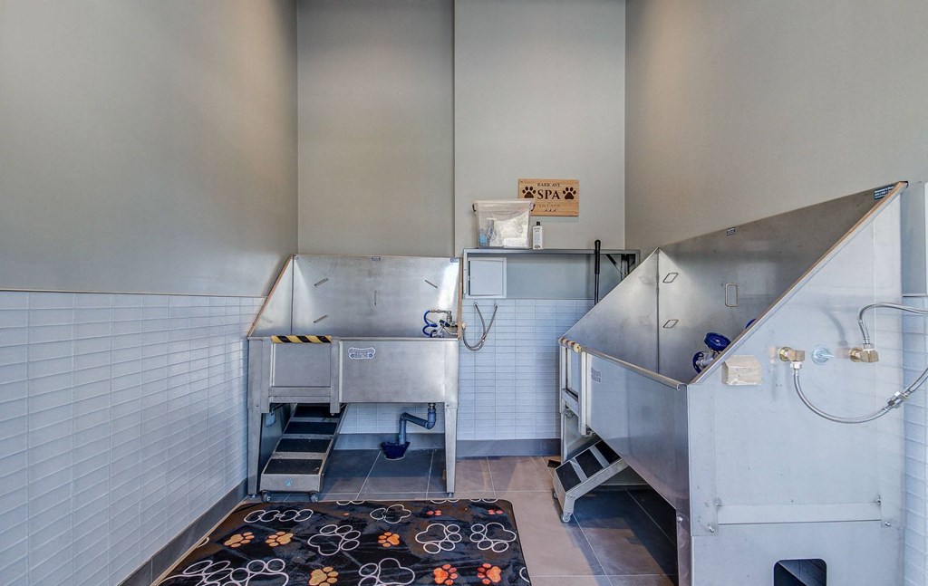 the kitchen has stainless steel appliances and a black rug