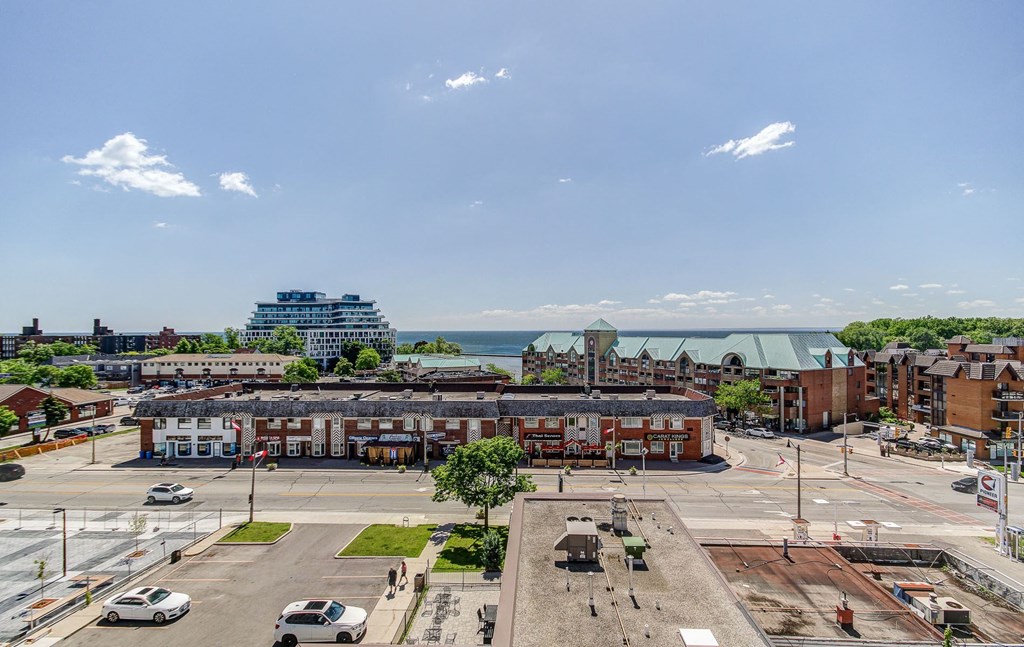 an aerial view of a city street with buildings and the ocean in the background