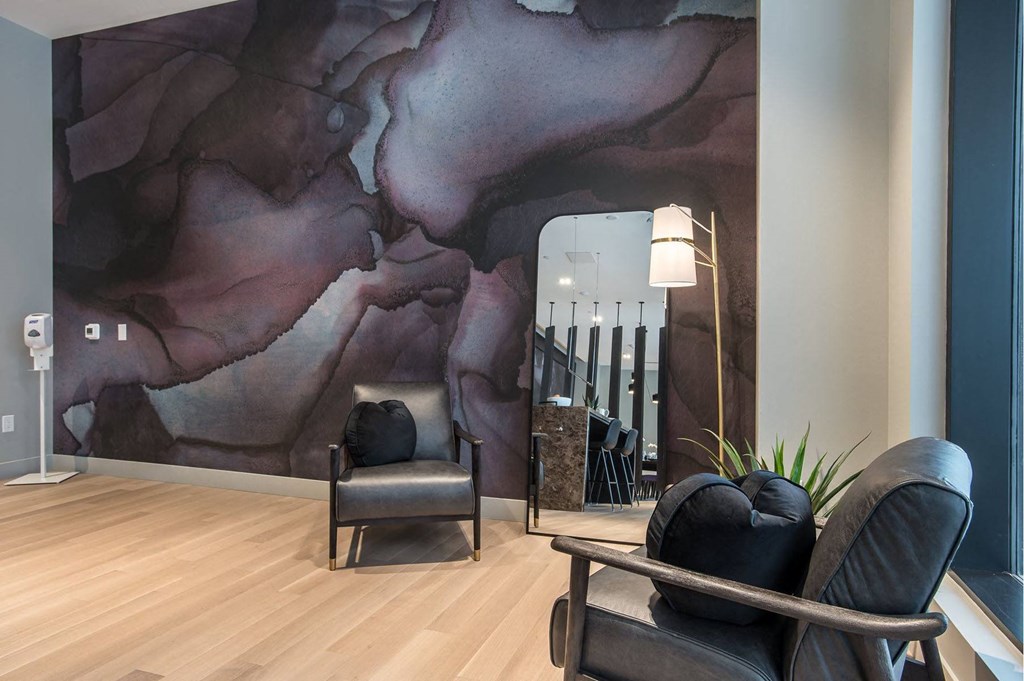 a living room with chairs and a wall mural