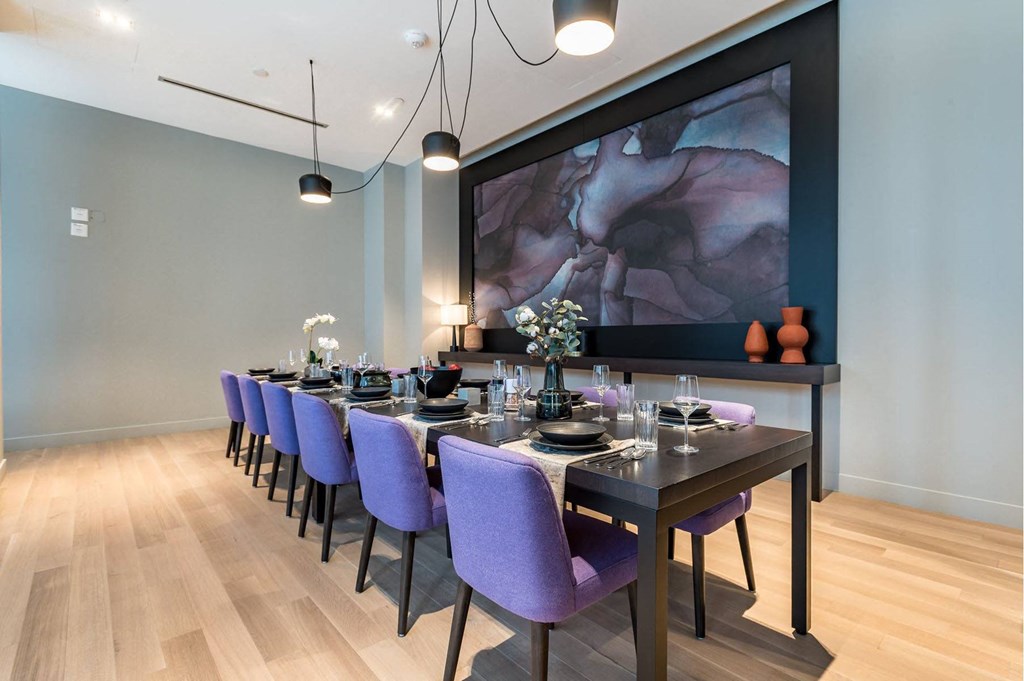 a dining room with a long table and purple chairs