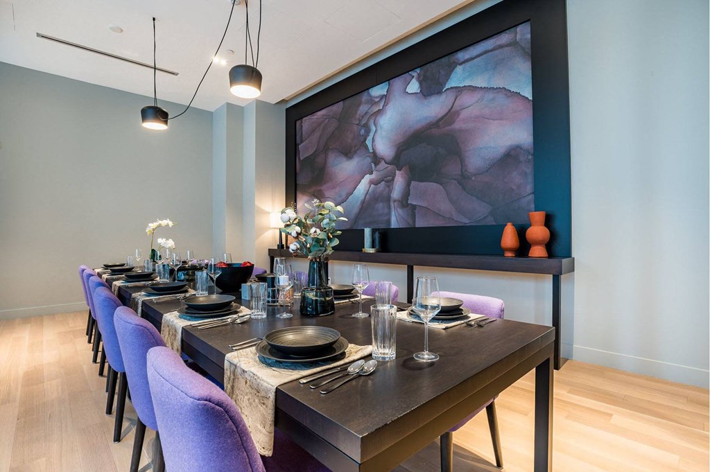 a dining room with a long table and purple chairs