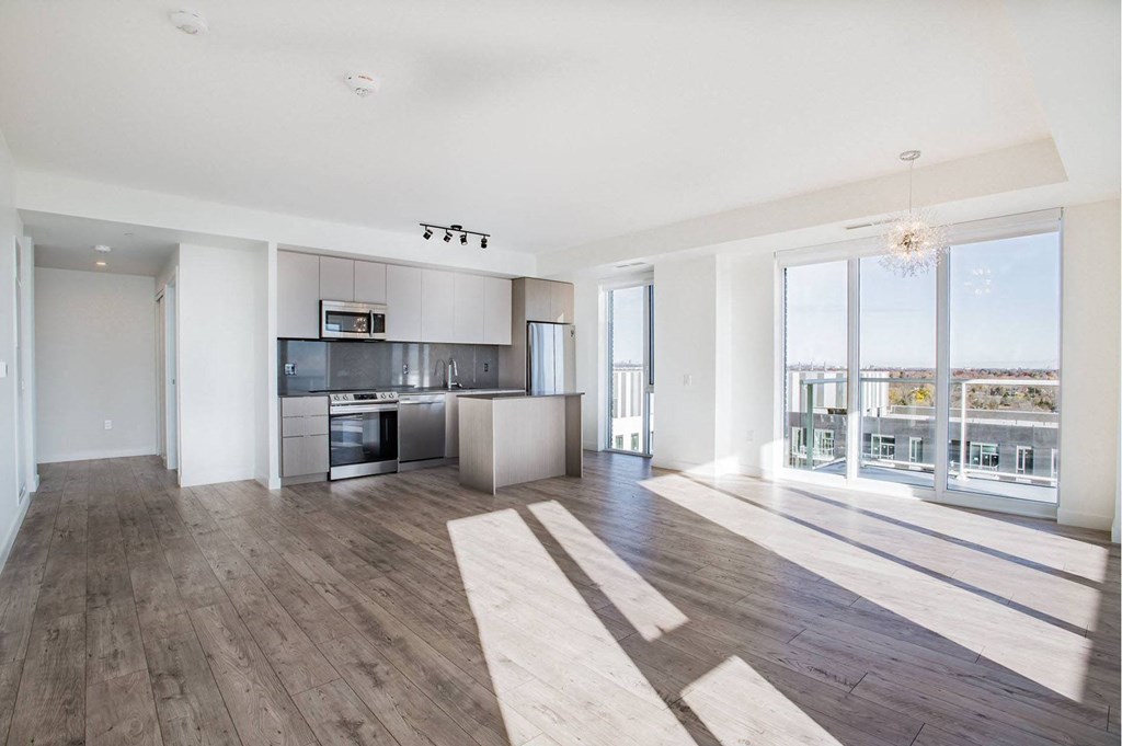 a living room with a kitchen and a large window