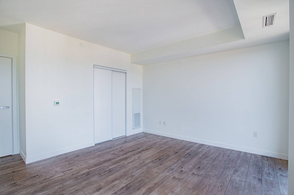 a living room with white walls and wood floors