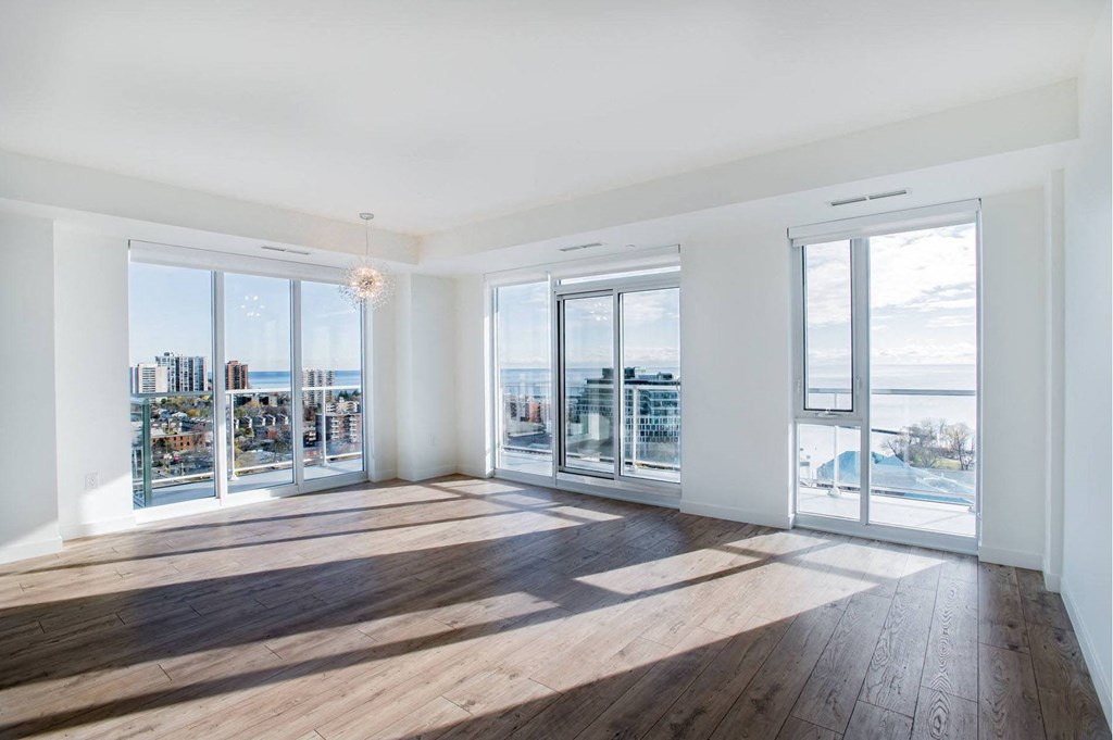 a living room with floor to ceiling windows and a view of the ocean