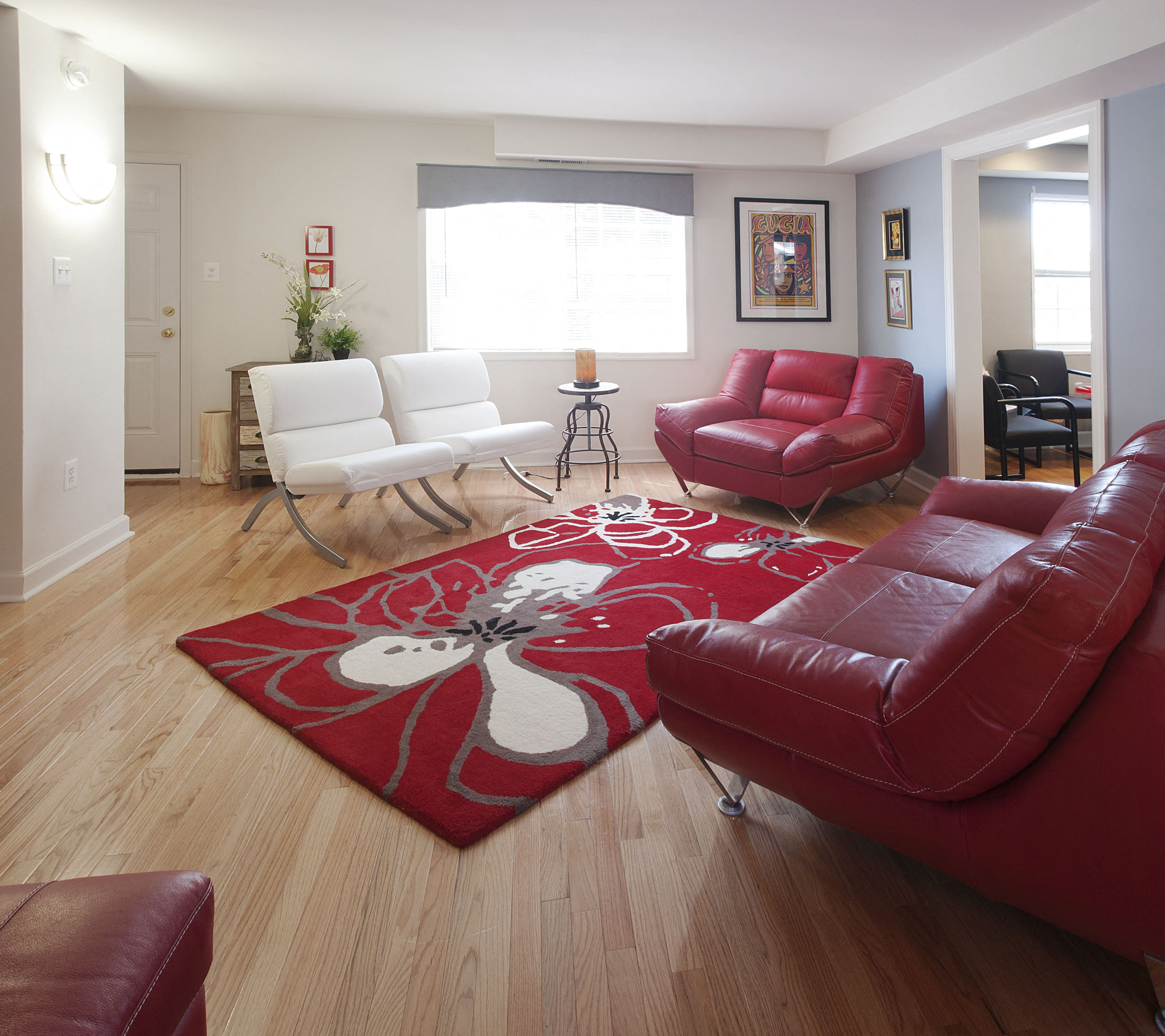 a living room with red leather furniture and a red rug