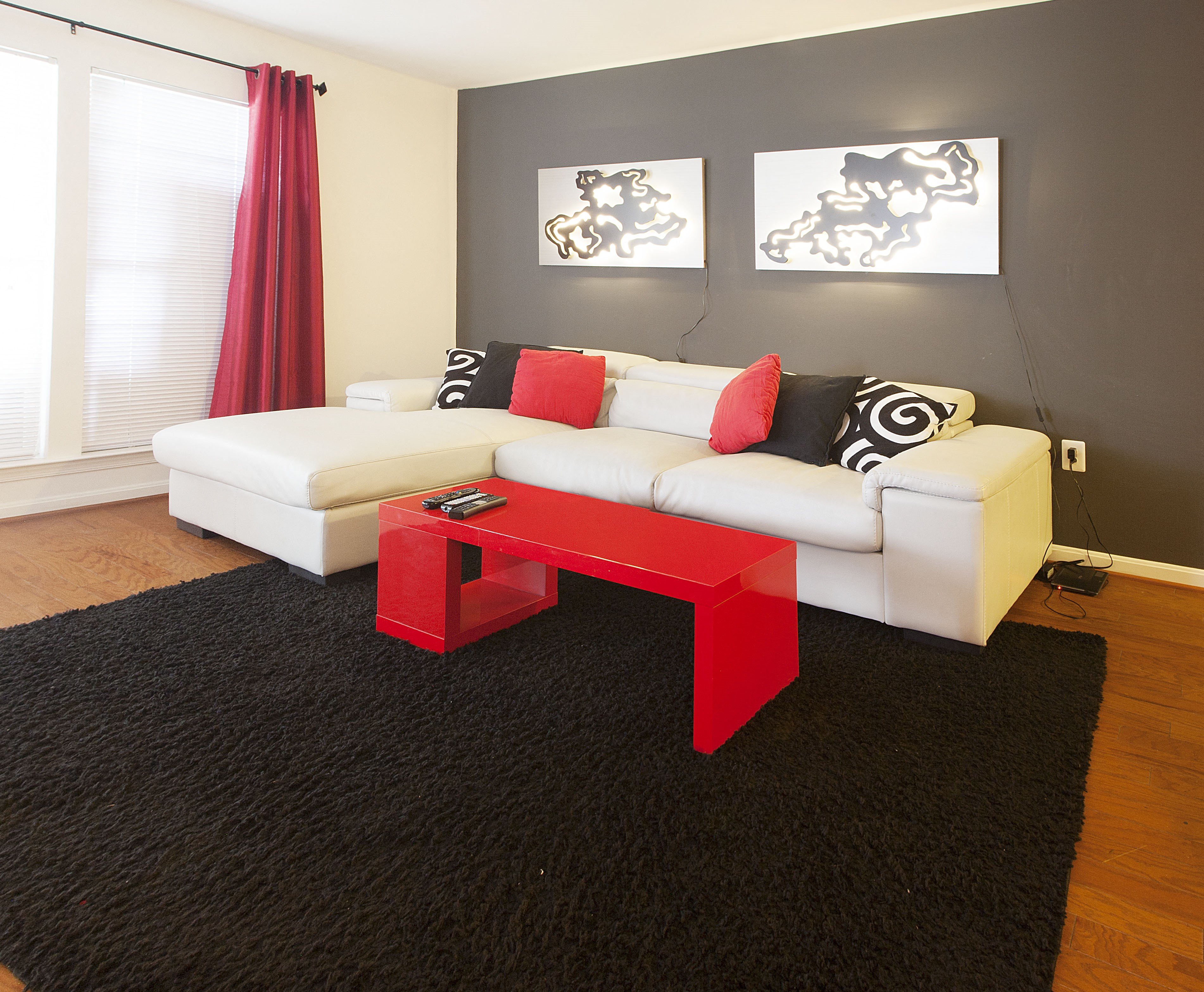 a living room with a red coffee table and a white couch