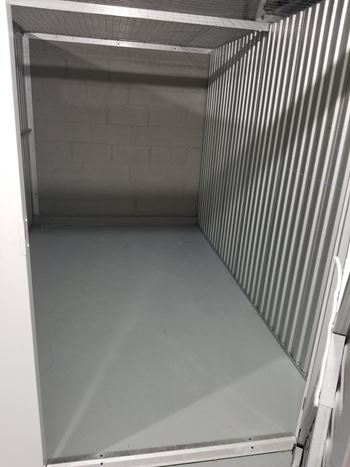 the inside of a prison cell with the door open