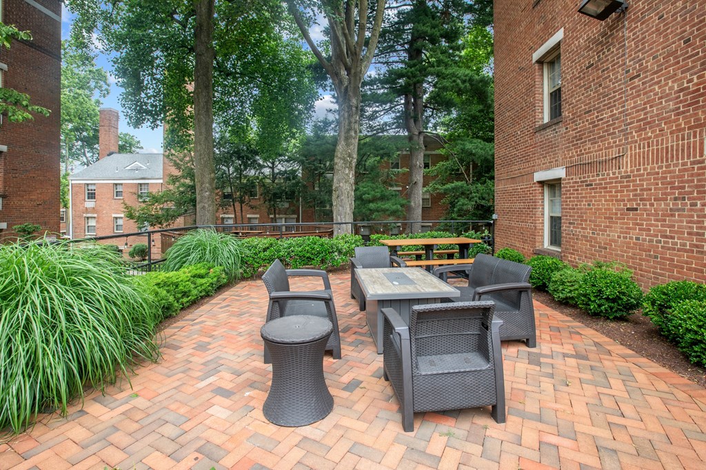 a brick patio with a table and chairs in front of a brick building