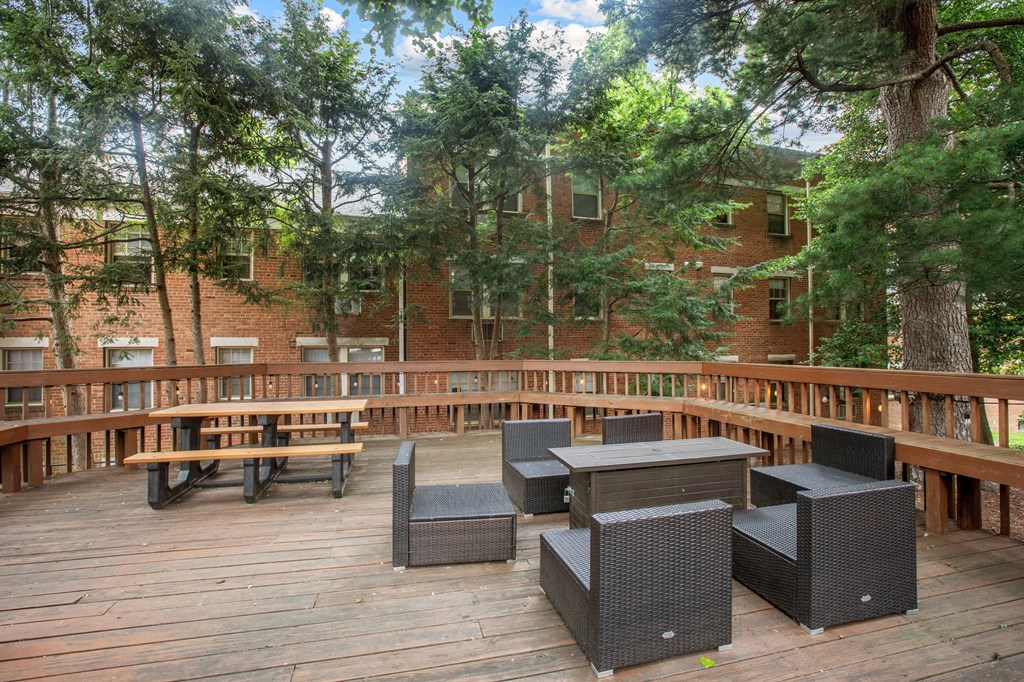 a patio with tables and chairs on a deck