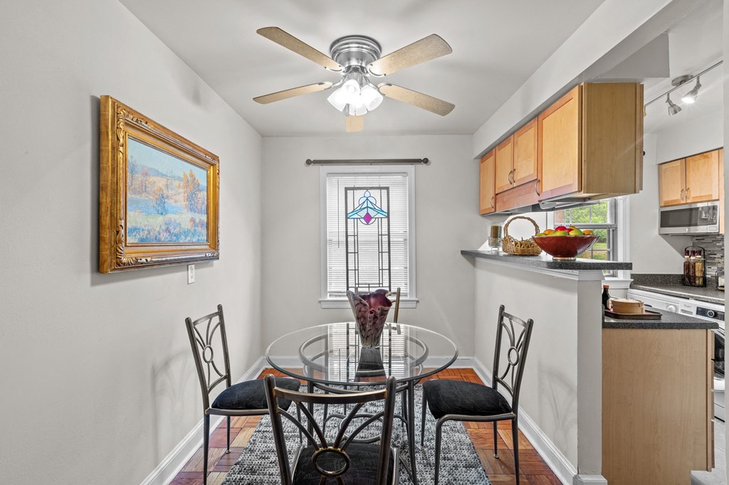 a dining room with a glass table and chairs and a ceiling fan