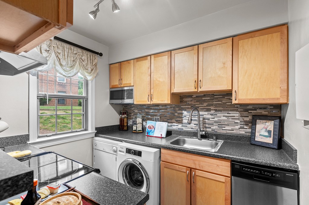 the kitchen has granite counter tops and wooden cabinets and stainless steel appliances and a window