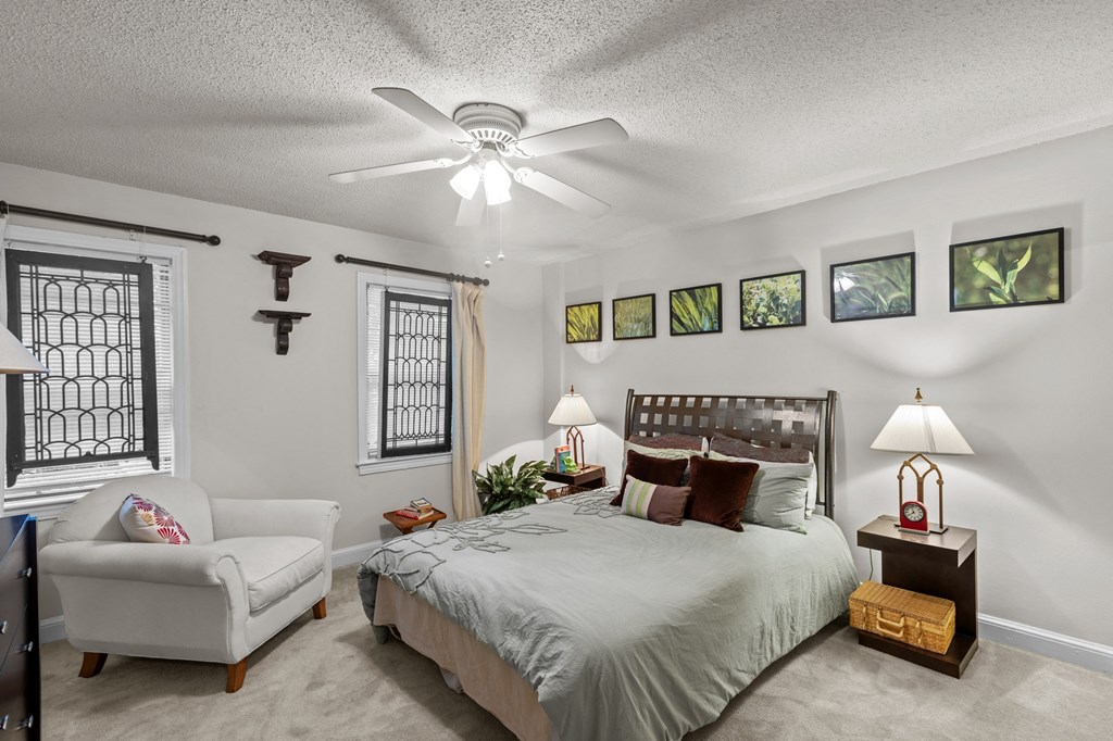 a bedroom with a large bed and a ceiling fan