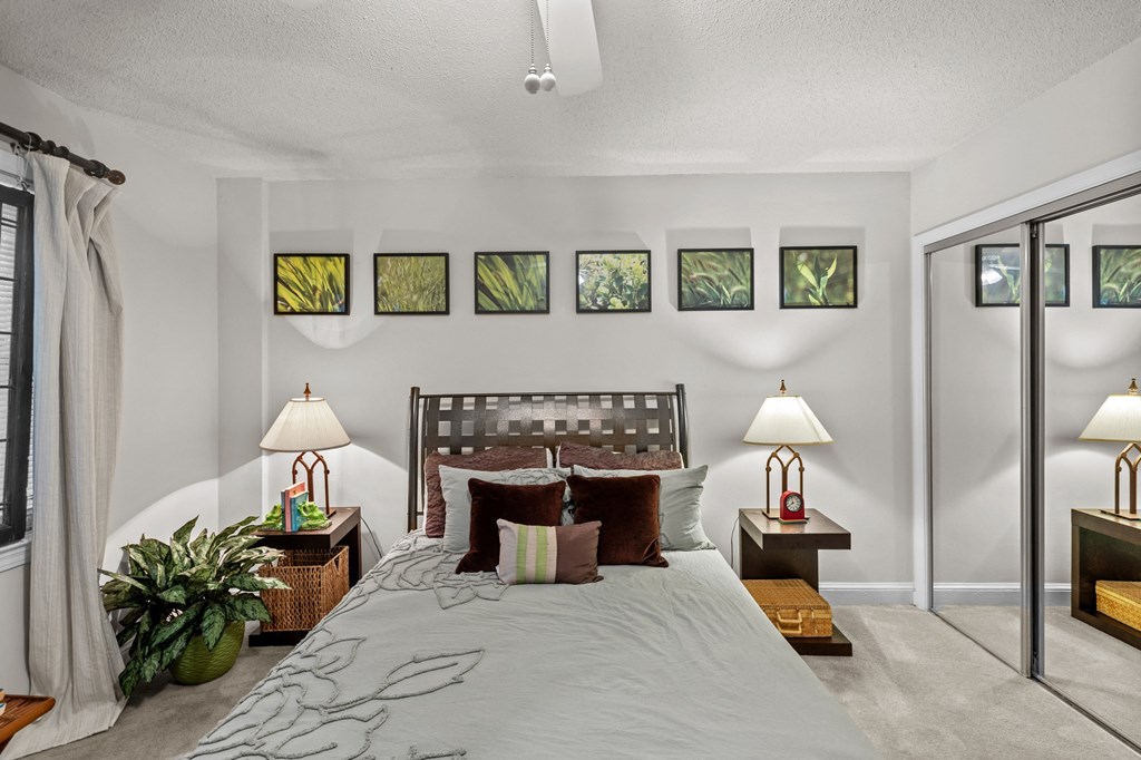 a bedroom with a bed and several pictures on the wall