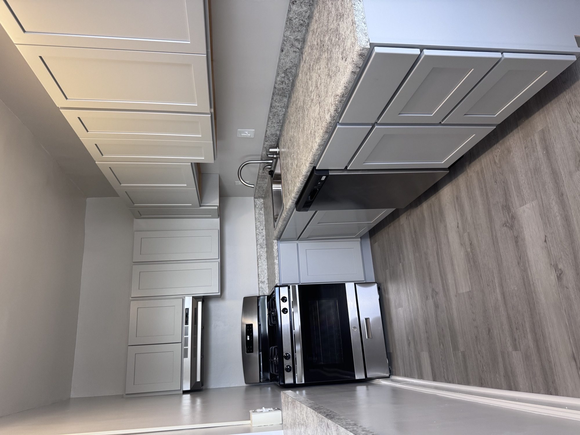 A modern kitchen with a stainless steel refrigerator and a white countertop.