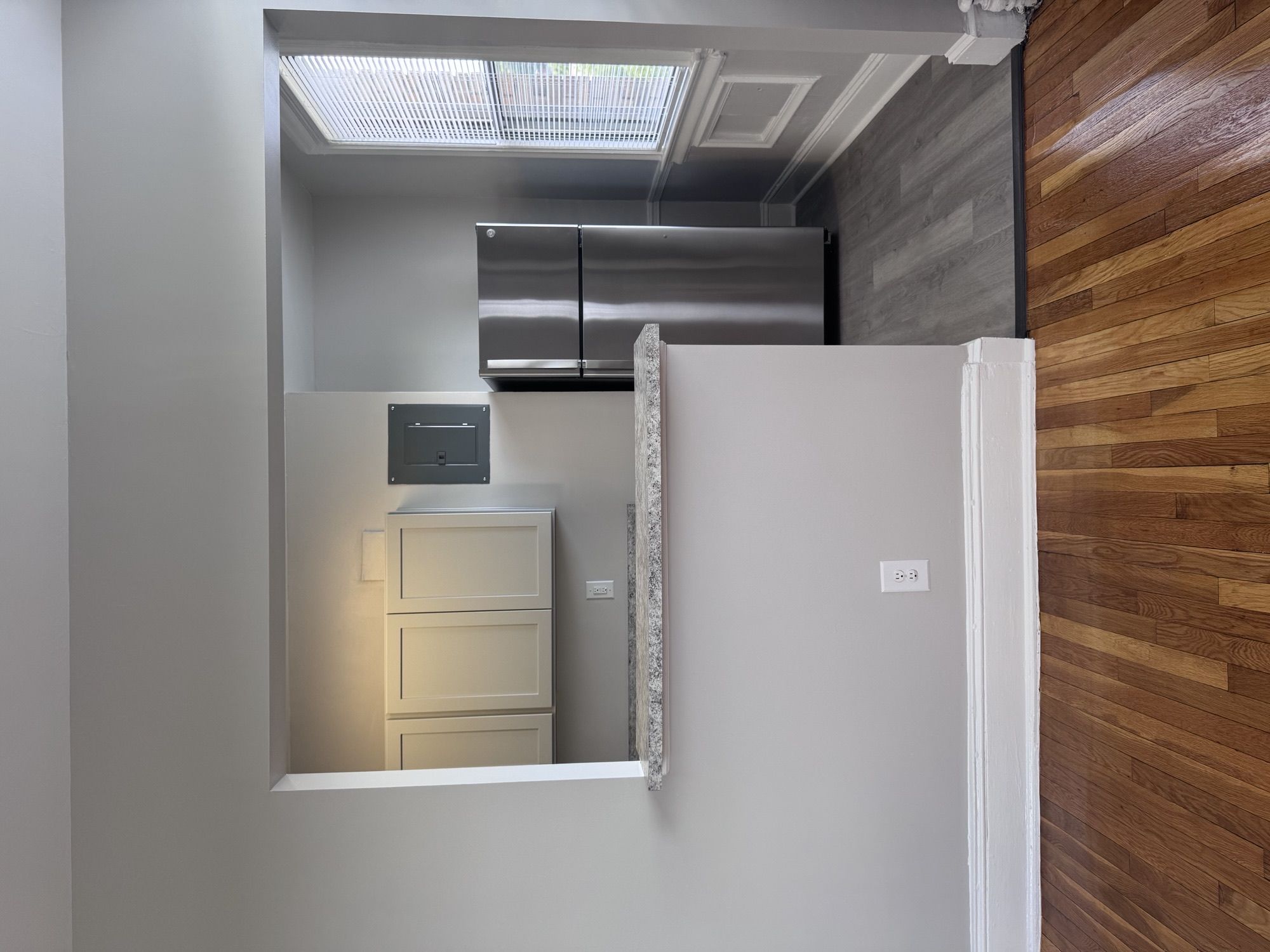 A small kitchen with a refrigerator, a microwave, and a cabinet.