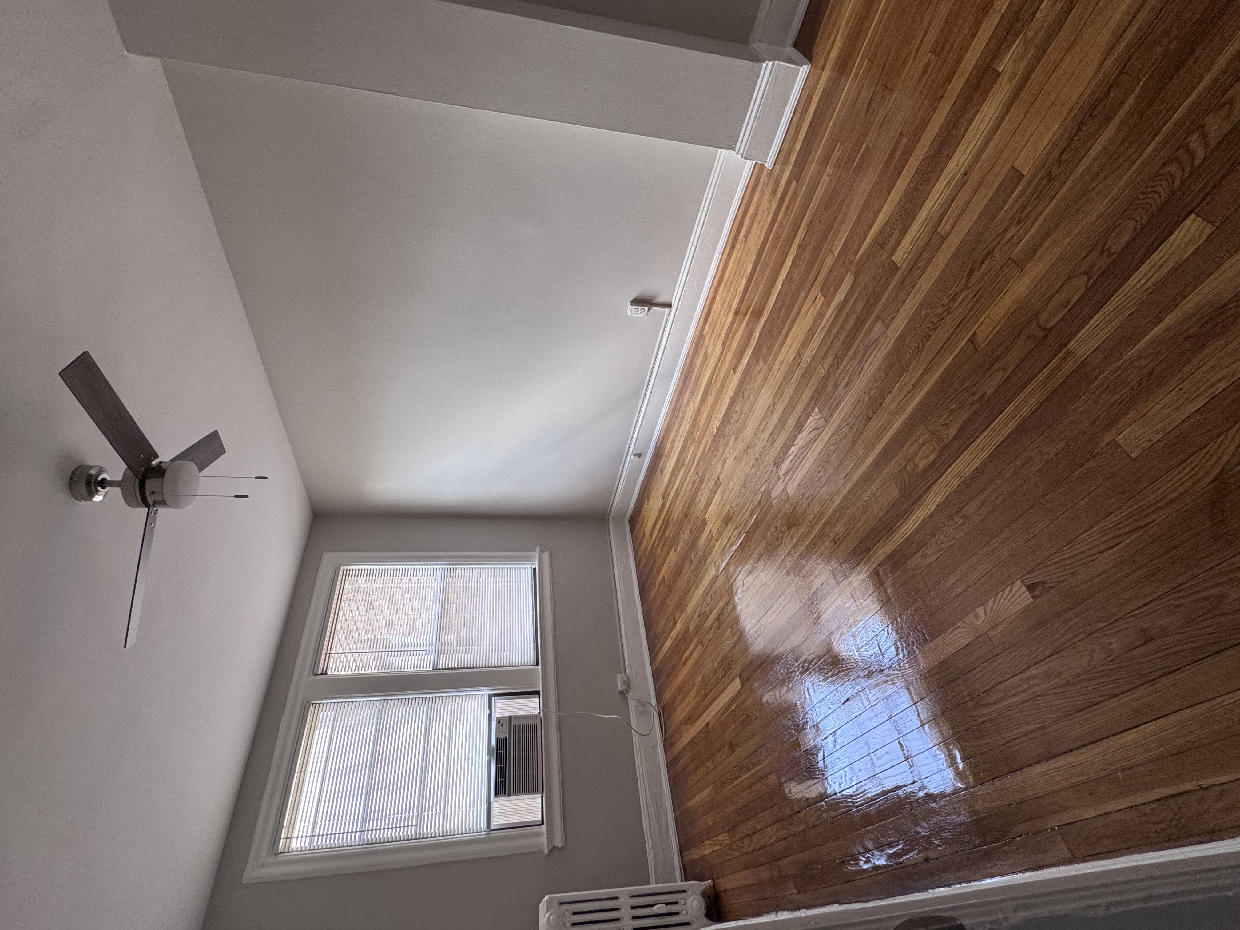 A room with a ceiling fan and a window.
