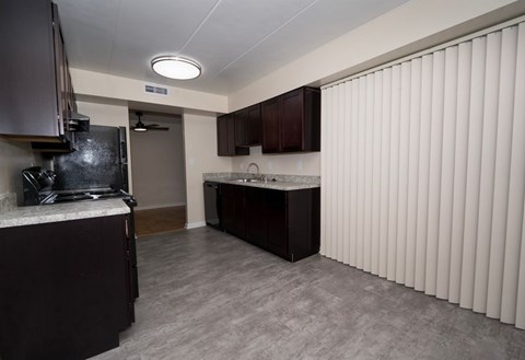 A kitchen with dark brown cabinets and a white countertop.