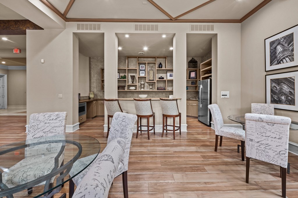 club house  with a glass table and chairs and a kitchen in the background