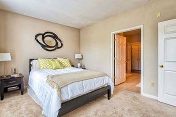 A bedroom with a bed, nightstand, and lamp.