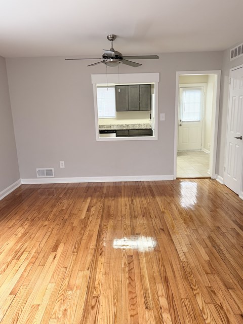 A room with a ceiling fan and a window.