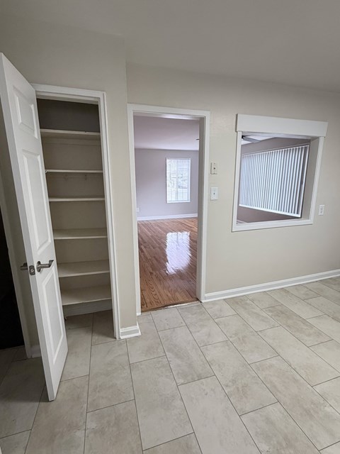 A room with a white door and a window with blinds.
