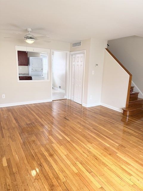 A room with wooden flooring and a staircase.