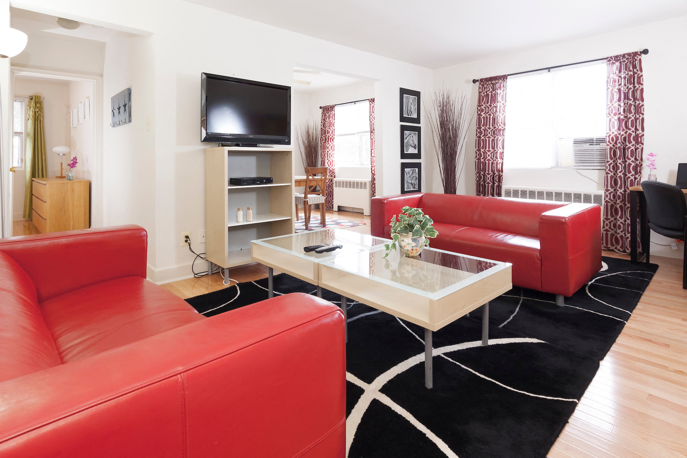 a living room with red couches and a table and a television