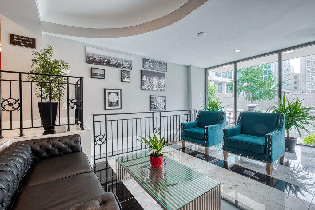 a living room with a couch and chairs and a balcony
