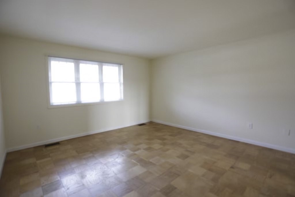 A room with a window and wooden flooring.at Normandy Hill Apartments, Virginia