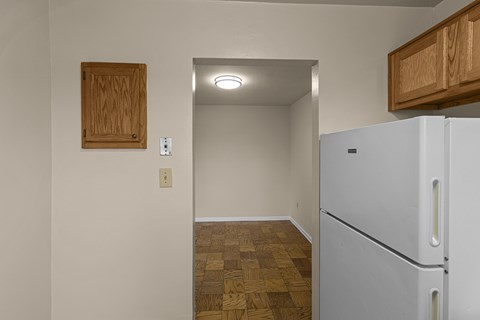 A kitchen with a white fridge and wooden cabinets.at Kensington House, Kensington