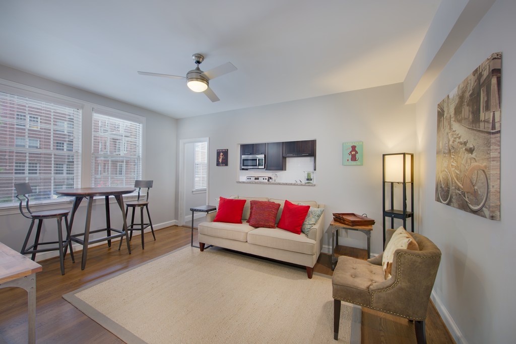 a living room with a couch and chairs and a kitchen with a table and chairs
