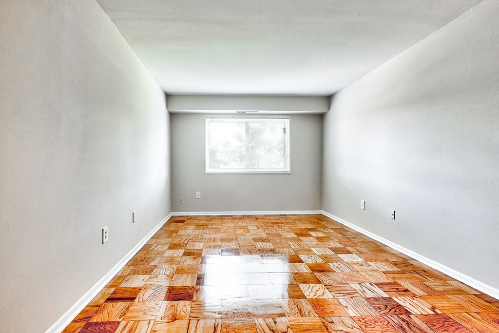 an empty room with wood floors and a window