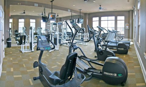 A gym with a variety of exercise equipment including treadmills and stationary bikes.