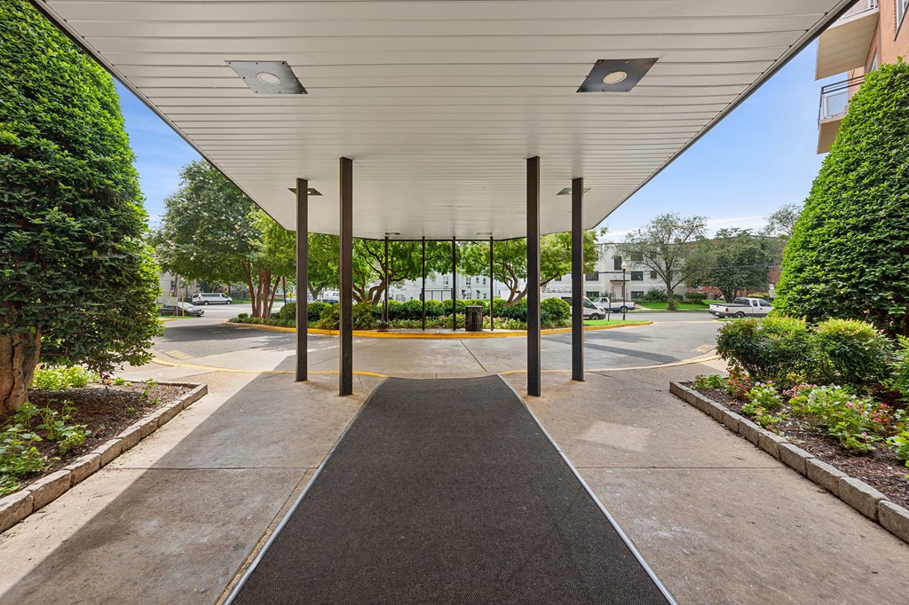 A covered walkway with a black pathway and a white ceiling.