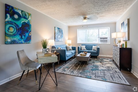 A living room with a blue couch and a white chair.