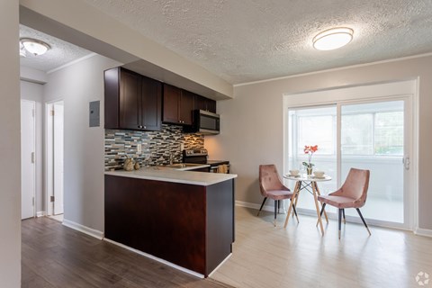 A kitchen with brown cabinets and a stone backsplash.