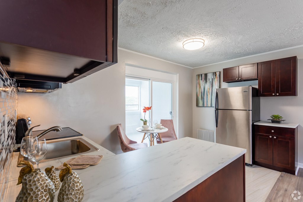A kitchen with a marble countertop and a refrigerator.at Greenbelt Properties, Greenbelt, MD