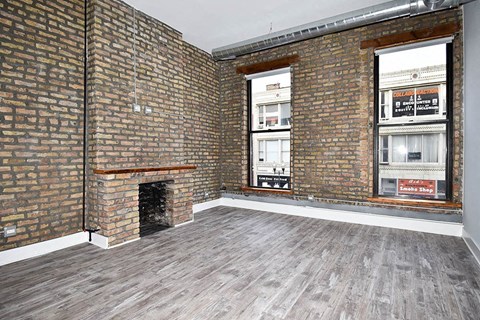 A room with a brick wall and a fireplace.