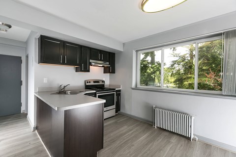 A modern kitchen with a stainless steel island and wooden flooring at Crescent Pointe Apartments, Greenbelt, Maryland