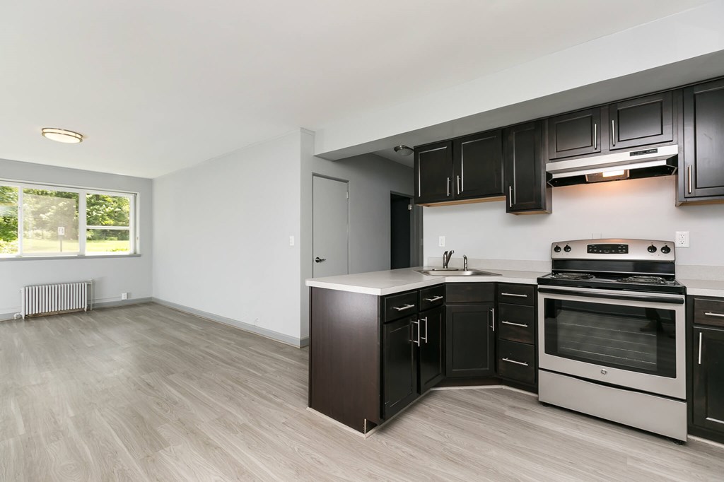 A kitchen with black cabinets and a stainless steel oven.at Greenbelt Properties, Greenbelt, MD