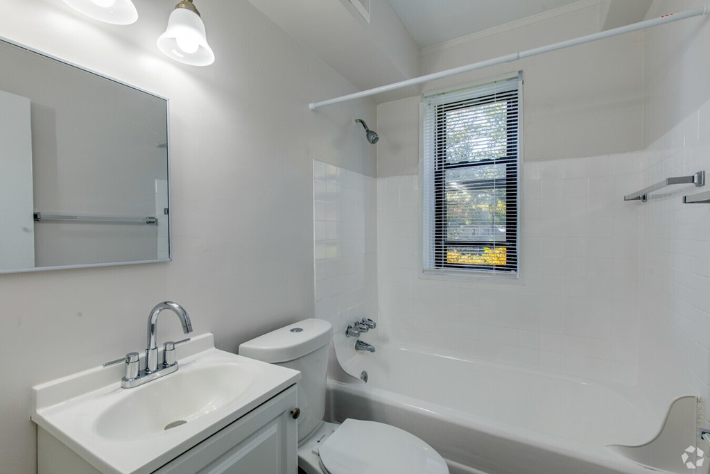 A white bathroom with a sink, toilet, and bathtub.at Greenbelt Properties, Greenbelt, 20770